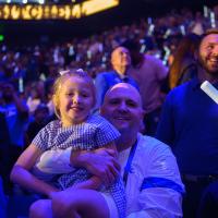 Dr. Adkins holds his daughter while sitting in the stadium at a UK game.