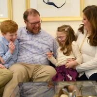 A photo of the Cook family laughing on the couch together.