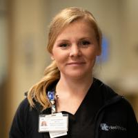 A close-up of Christa smiling for the camera in one of the hospital’s hallways.