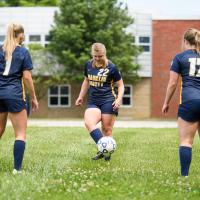 Audrey, Alison and Amelia passing a soccer ball as a group.