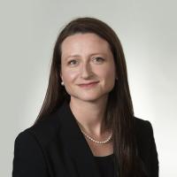 Dr. Claire Fraser, a middle-aged white woman, smiles for a photo in a black blazer.