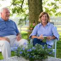 E and Cary sit in lawn chairs and laugh.