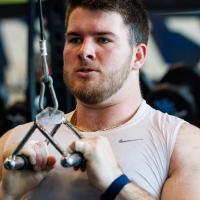 A candid photo of Eli using one of the weight-lifting machines at the gym.