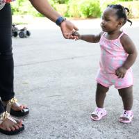 A candid photo of Betty walking at the playground while holding her mother’s hand.