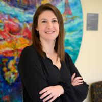 A photo of Dr. Bandi Mahaffey smiling and posing for the camera with her arms crossed.