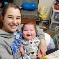 A photo of Claire holding Everett, both have beaming smiles.