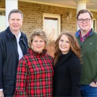 Fielden, her brother, and her parents all stand for a group portrait in front of their home.