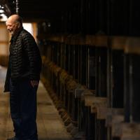 A candid photo of Fred and DeeAnn smiling as they laugh inside the barrel aging warehouse.