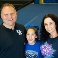 Gracie and her parents pose close-up to the camera while smiling