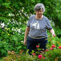 A candid photo of Helen watering some of the plants in her garden.