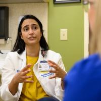 Dr. Ramachandran is in an office having a conversation with Jennifer, whose back is to the camera—she is out of focus.