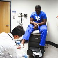 Dr. Peng Wang bandages Josh's foot up with gauze.