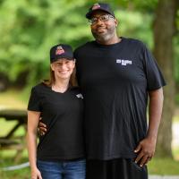 A photo of Joshua and Jill with their arms around each other as they smile for the camera.