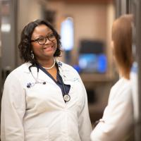 Joy smiles at another nurse in a hall at UK HealthCare.