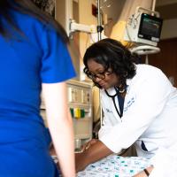 Joy listens to her patient's heart with her stethoscope.