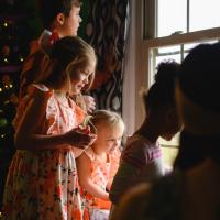 Standing next to the Christmas tree inside the house, Julie, her siblings, Jennifer and her daughter stare out the window.