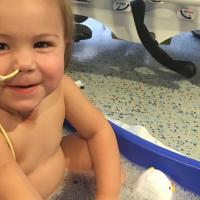 A photo of baby Kailey getting a bath while in the hospital. She has a feeding tube that is in her nose.