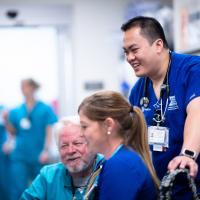 Khay smiles while talking to two other emergency room nurses.