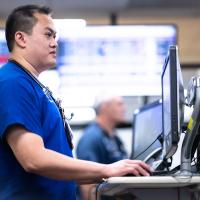 Khay works at a desktop work station in the emergency room.