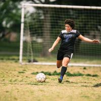 UK HealthCare cancer patient, Kylee Tyson, kicking a soccer ball.