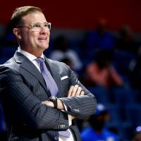 Coach Mitchell in a nice suit watches as his team plays.