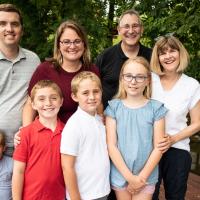 A group shot of Max and his family, including his grandparents, standing together in an outdoor setting.