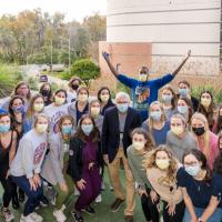 A group photo with Michael, a professor, and a number of University of Florida students. Michael has his hands up in the air.