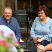 Michael and his family sit around a patio table as they drink coffee and talk.