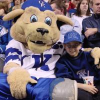 A photo of Jarrett smiling for the camera as he poses with the UK mascot.