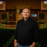 A photo of Omar inside of the Keeneland auction floor, smiling for the camera.