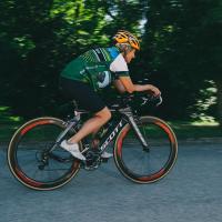 Action shot of Patty quickly biking past on the road outside.