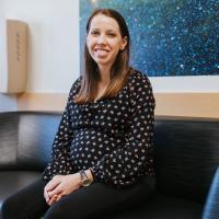 A photo of Dr. Harrington smiling as she sits on the couch.