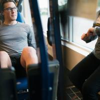 Peter works out with a machine while a physical therapist times him.