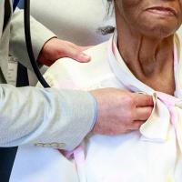 A doctor listens to Priscilla's heart with a stethoscope.