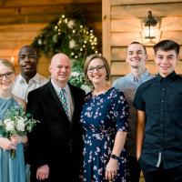 All dressed up, Remilson, the Morgan family and a few friends stand together and smile for a photograph.