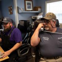 Chuck answers the phone at the Gold City Towing office.