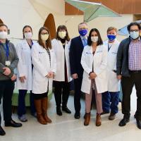 Rory’s team of medical workers—men and women—are standing side by side inside the lobby of Kentucky Children’s Hospital. They are all wearing facemasks and some are in doctor’s coats.