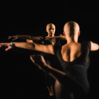 Savannah practices a dance pose in front of a large mirror at her dance studio.