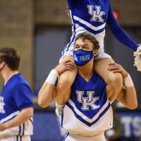 A candid photo of Travis during the same game, while a female cheerleader sits on his shoulders.