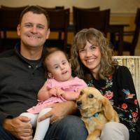 Karla, Gavin, Wylie, and their Dachshund smile and pose for the camera.