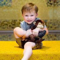 Ezra cuddles his new Stinky Monkey and smiles.