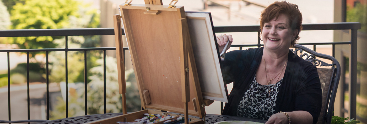 Teresa Schladt paints a picture on her porch.