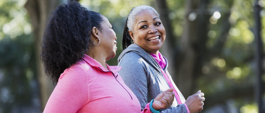 Two women walking in park. 