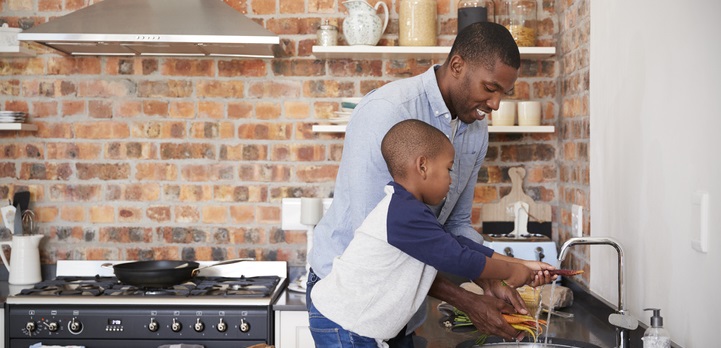 Dad washes carrots with his son.