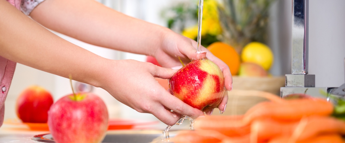 A woman washes an apple.