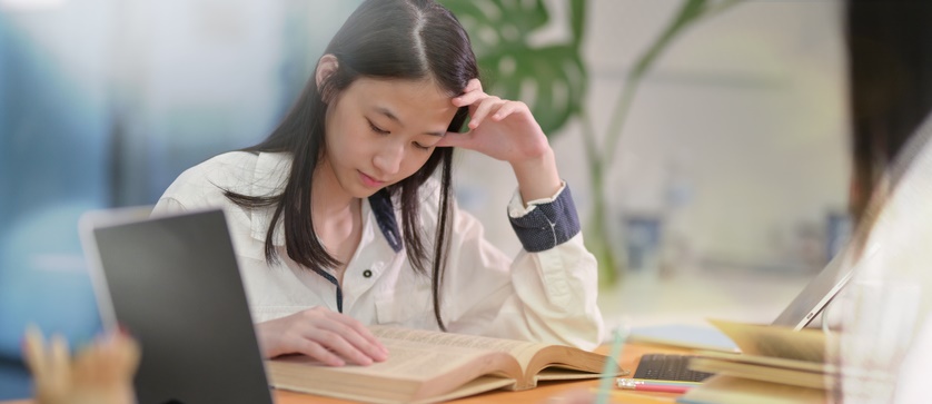 A young girl reads a book.