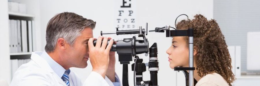 A young woman is having her eyes examined.